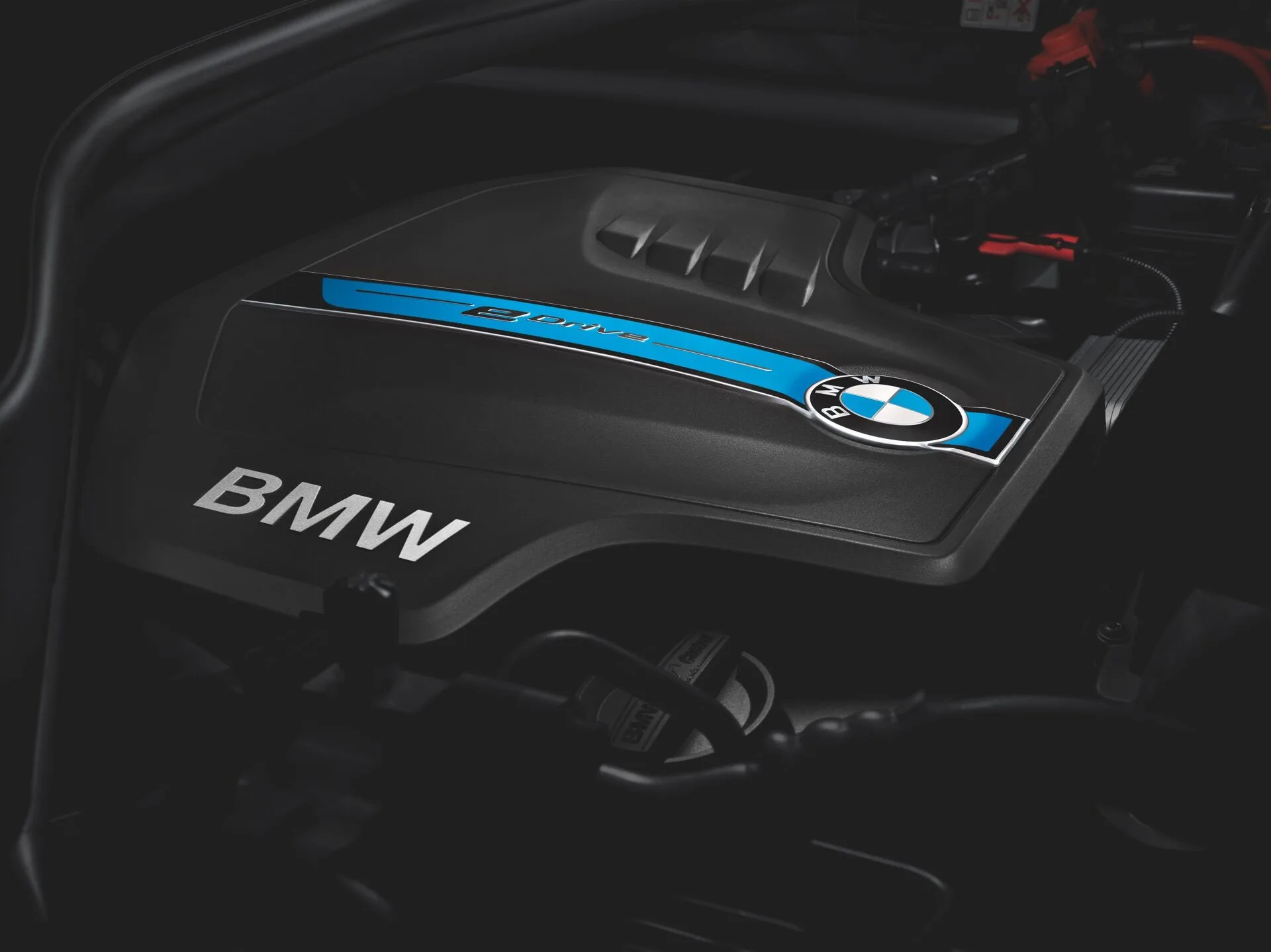 Kaltenbach Gruppe – Nahaufnahme einer BMW Motorabdeckung mit BMW Schriftzug, blauem Akzent und Logo, die auf ein Hybrid- oder Elektromodell hinweisen. Der sichtbare Motorraum hebt fortschrittliche Technik und Serviceleistungen für zuverlässige Termine und Wartung hervor. – BMW, MINI, KIA, BMW Motorrad & Honda Motorrad Partner in NRW