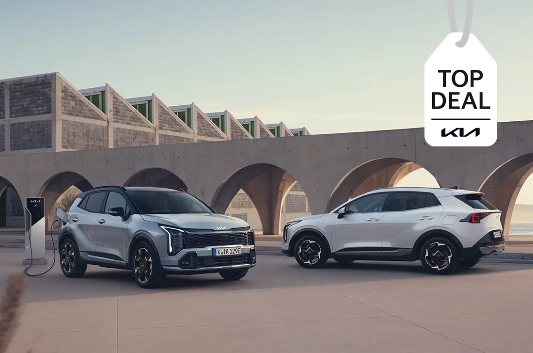 Kia Sportage in Weiß und Grau vor einer Arkaden-Architektur am Meer